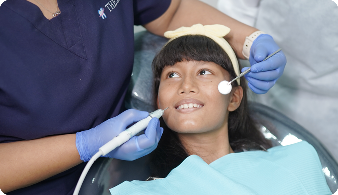 A 15 years old girl receiving dental treatment from dentist with gentle care