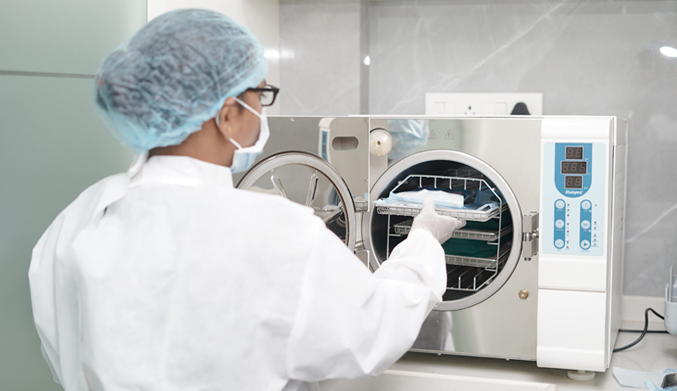 Modern autoclave machine used by assistant for washing and sterilizing dental tools in a clean and sanitary dental clinic environment