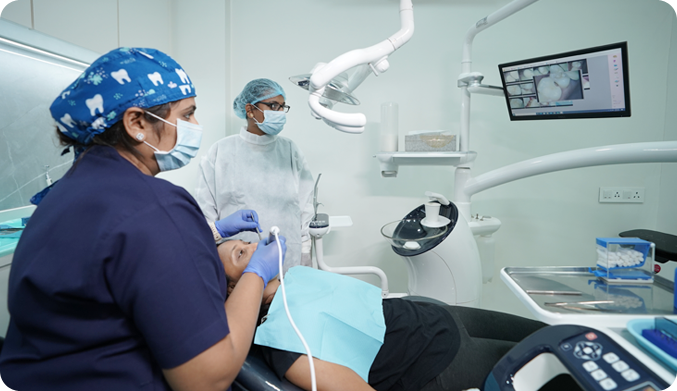 Dr. Chaitali performing root canal treatment on patient with her assistant in clean and well light environment